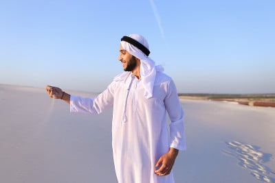 在晴朗的夏日午后，穆斯林男子在沙漠中的肖像