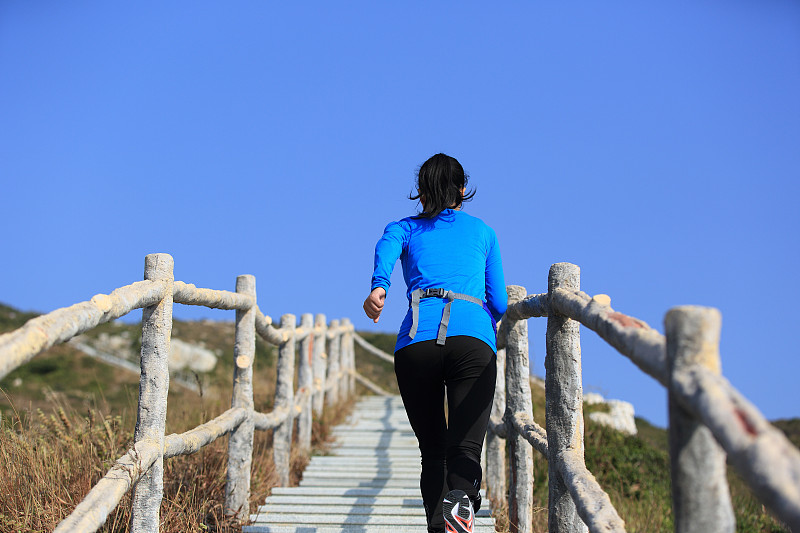 一个健康的女人跑上了山上的楼梯