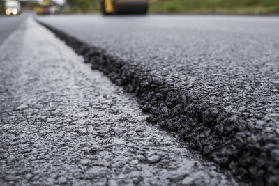 沥青压路机用重型振动压路机压实新型热沥青路面，在某道路施工现场。重型振动压路机在沥青路面工作。修理。