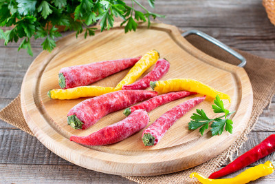 冻辣椒放在桌子的木板上。冷冻蔬菜。冷冻食品