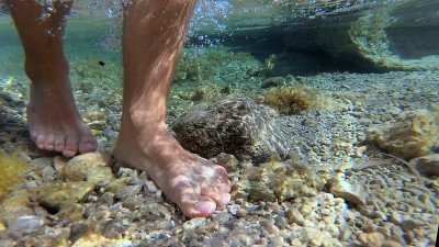 人脚行走在岩石地中海海岸水下