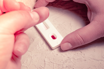 HIV自检手指蘸一滴血。艾滋病毒检测表达。