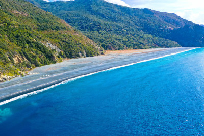 鸟瞰图黑色卵石海滩，Nonza，地中海灌木丛，山坡靠近海岸。科西嘉岛的科斯角半岛。海岸线。法国
