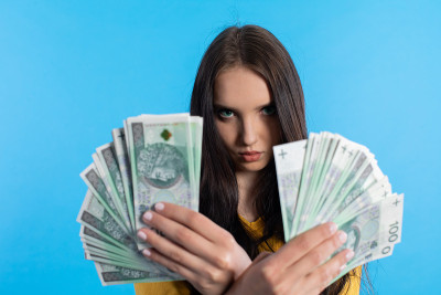 这名年轻女子手持一把面值为100兹罗提的纸币扇子。
