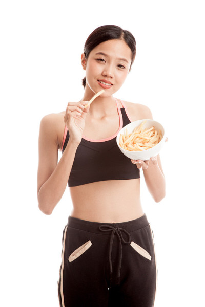 美丽的亚洲健康女孩吃薯条