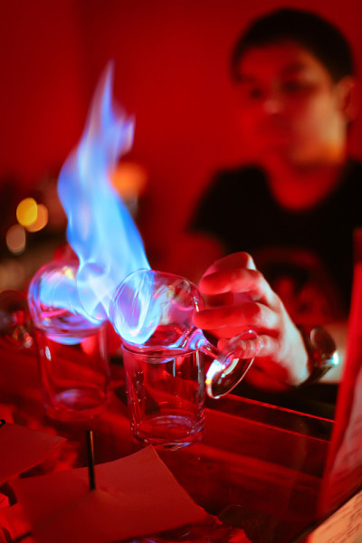 酒保在酒吧里烧桑布卡酒