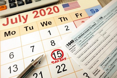 显示日期为2020年7月15日的月历，以1040表格计算器和笔标记为纳税日