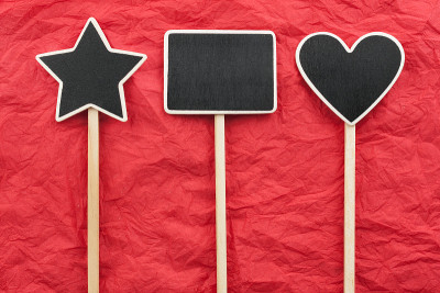 Sign, star, house, heart lie on the red crumpled p
