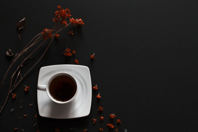 茶杯的特写茶在深灰色的背景与花。