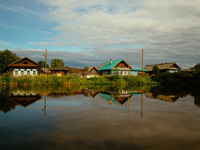 Houses in the village by the lake are reflected fr