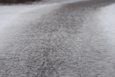 在城市公园里，有自行车打滑痕迹的沙质人行道和冬天的冰雪