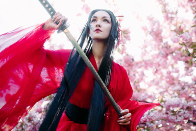 年轻女子描绘艺妓与剑在她的手附近盛开的樱花树。