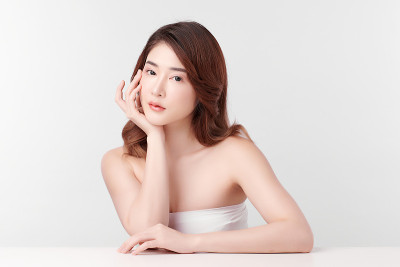 美丽年轻的亚洲女性与干净的新鲜皮肤在白色的背景，面部护理，面部治疗，美容和水疗中心，亚洲女性肖像。