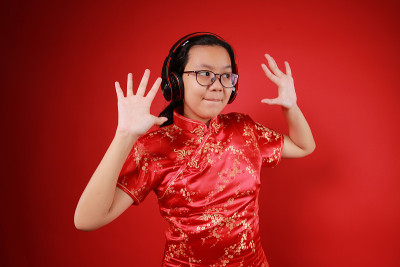 年轻的女孩穿着旗袍，戴着头套跳舞