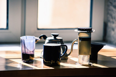 咖啡背景与空气压设备，磨碎的咖啡，茶壶，和马克杯。所有的工具来冲泡替代咖啡。