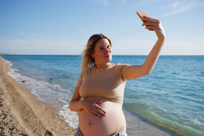 年轻孕妇在海边自拍