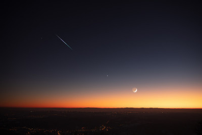 行星、星星和月亮在明亮的天空和乡村街道上