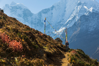女背包客站在步道，康加山山脊雪峰。
