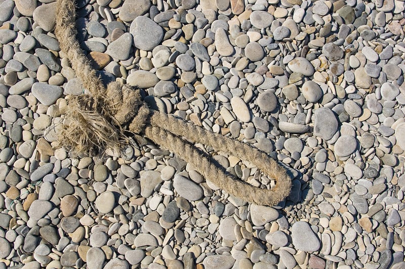 old marine rope on the pebble beach