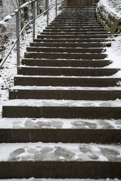 冬天，长长的覆盖着积雪的楼梯上有台阶和脚印