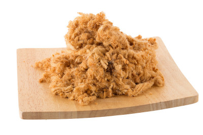 干猪肉丝在一个木制托盘孤立在白色背景
