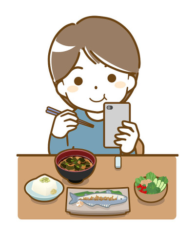 用餐时使用智能手机的年轻人