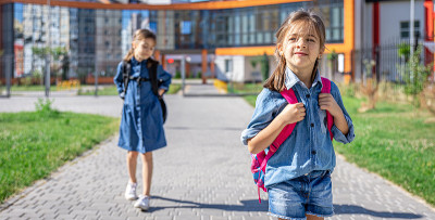 小女孩，小学生背着书包离开学校。