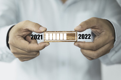 商人拿着带有加载进度条的木方块，迎接新年，2021年到2022年。