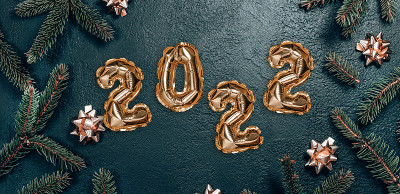 创意圣诞背景与绿色冷杉枝和2022文本金箔气球装饰。