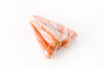 白色背景的塑料袋里的新鲜胡萝卜