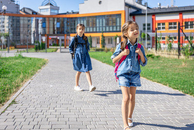 小女孩，小学生背着书包离开学校。