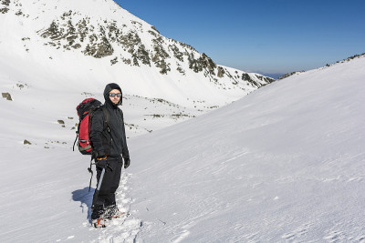 一个美丽的有霜冻的早晨非常适合登山旅行。山脊上一个男人的肖像。