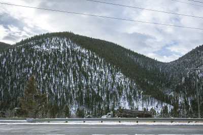 满载木材的卡车在雪山路上行驶