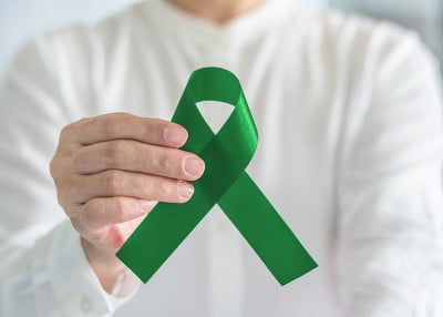 肝癌和乙型肝炎的意识概念象征以翠绿色或玉色丝带在人的手中