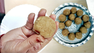 女人的手握着一个用芦荟和干果制成的laddoo。有选择性的重点