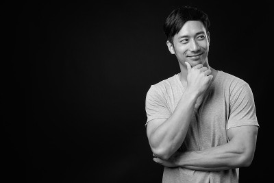 年轻英俊的亚洲男子与黑人背景