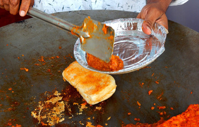 印度街头小吃摊贩制作的vada pav，用马沙拉填充面包