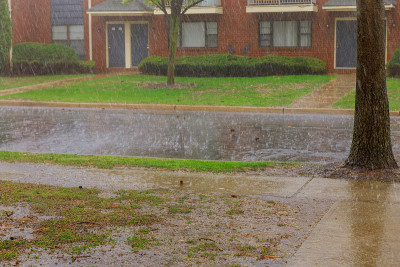 雨季强降雨公寓大楼在强风下，大雨雨滴落在沥青上
