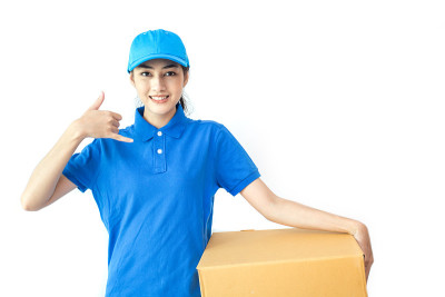 年轻的亚洲女人和穿制服的快递员。女人拿着盒子迷人的微笑孤立在白色的背景。