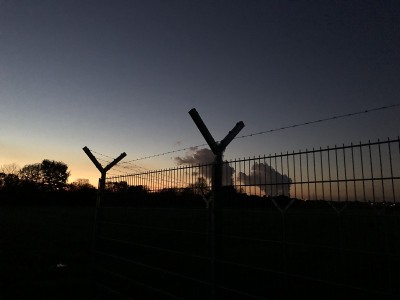 夕阳下有铁丝网的安全围栏