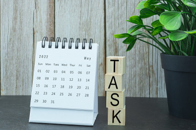 白色2022年5月日历，任务文本在木块上。新年的概念