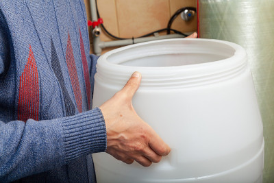 水处理室内，手握塑料容器