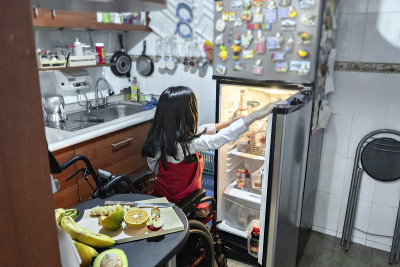 残疾拉丁美洲妇女在冰箱里寻找食物