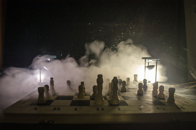 棋牌游戏的经营理念和竞争理念以及战略理念。象棋人物在烟雾缭绕的黑暗背景上。