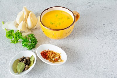 在一个碗(杯)里放上自制的鸡骨汤，配上蔬菜、香料和香草。动物来源的天然胶原蛋白。肉汤，鱼汤，蔬菜汤。