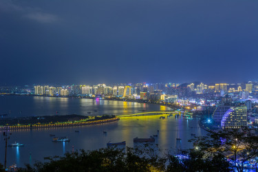 夜景三亚市与明亮的彩色照明建筑，结构，道路，人行道，杆子，桥梁。