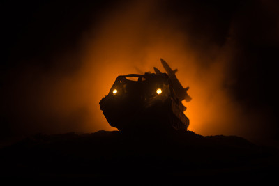 火箭发射与火云。火箭导弹和弹头瞄准夜晚灰暗的天空的战斗场景。《战争背景》中的火箭战车