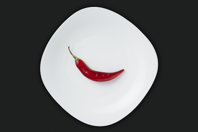 孤立的红辣椒在黑色的石头背景，理想的配料辛辣和激情的食谱