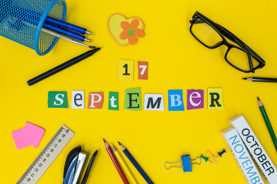 9月17日。月17日，回归学校理念。日历上有老师或学生的工作背景，黄色的桌子上有学习用品。秋天的时间