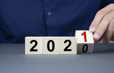 男性的手拿着一个木制的立方体特写，里面有改变2020年到2021年的概念和操作结果。木方上的数字20